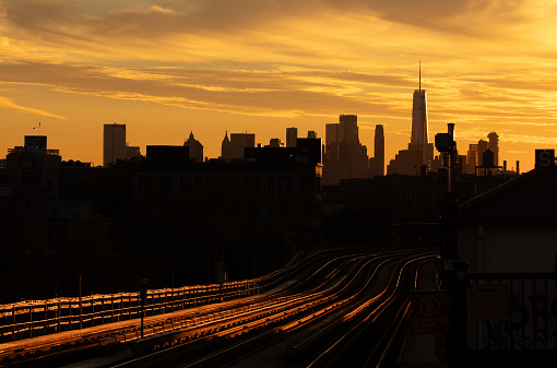 Subway railroad tracks and the Manhattan skyline at sunset
