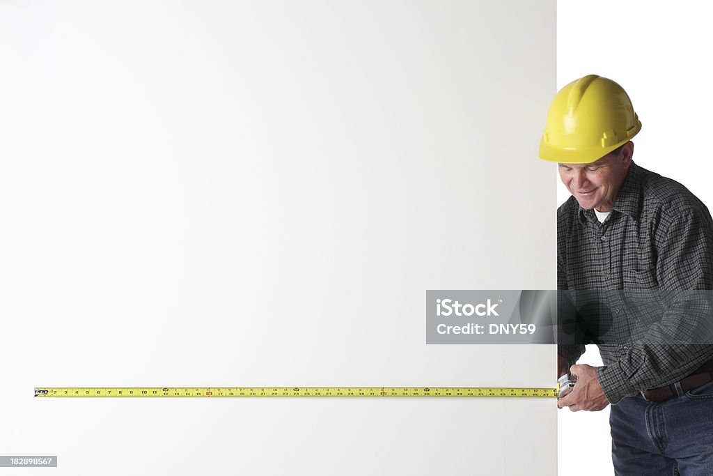 Measuring A construction worker using a tape measure.To see more blue collar workers click on the link below: Construction Worker Stock Photo