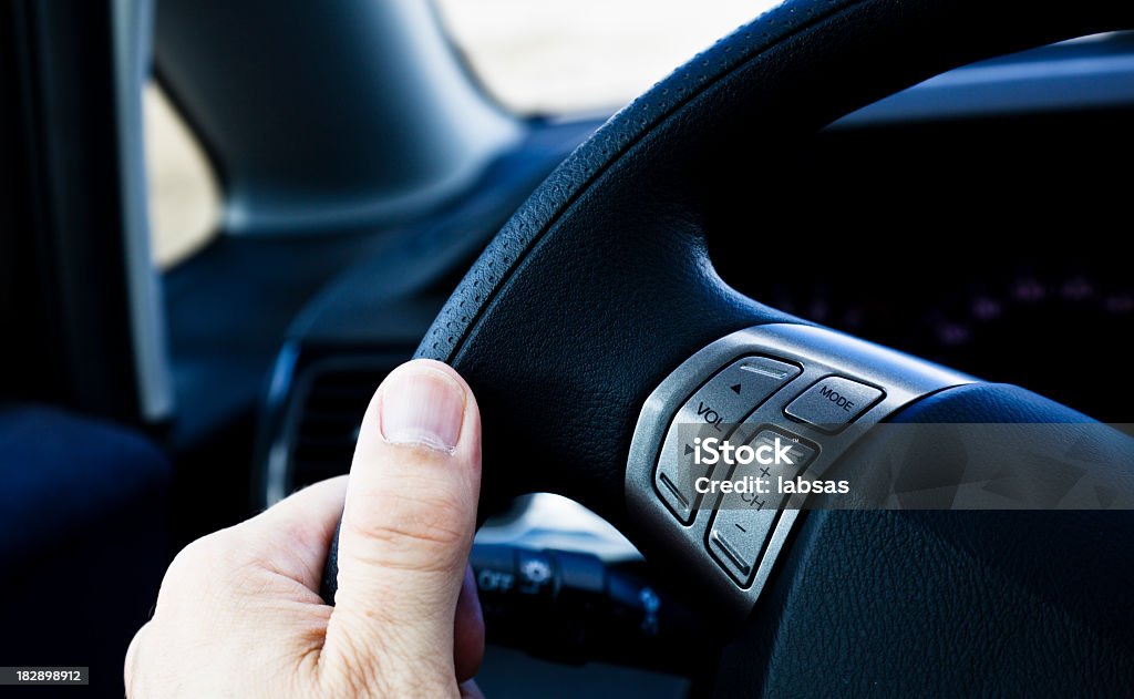 La main sur le volant avec boutons-radio. Conduire le véhicule. - Photo de Voiture libre de droits