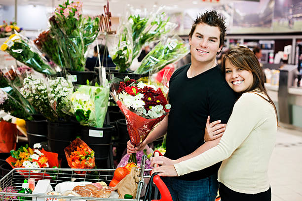 優しい笑顔の若いカップル花のスーパーマーケットの購入 - florist supermarket flower bouquet ストックフォトと画像