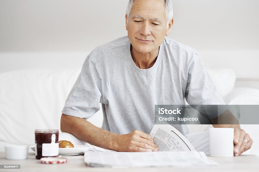 Senhor idoso lendo jornal com um café da manhã na mesa - Foto de stock de 60 Anos royalty-free