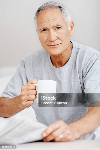 Starszy Mężczyzna Trzymać Newpaper I Filiżanką Kawy W Domu - zdjęcia stockowe i więcej obrazów 60-64 lata