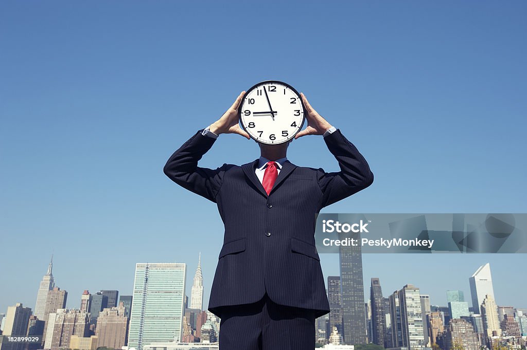 Clock Face Businessman Stands at Skyline Businessman stands in front of the city skyline with a clock in front of his face nearing 9 o'clock Clock Stock Photo