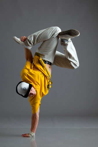 Break dancer stand on one arm isolated on gray background