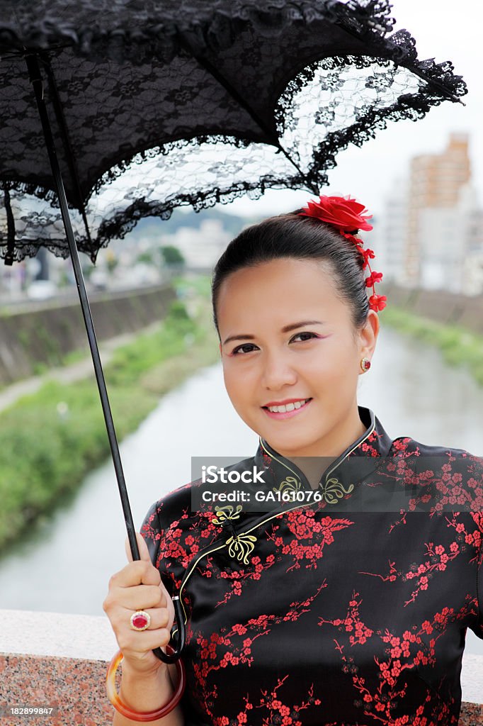 Joven mujer en vestido de China con paraguas contra city street - Foto de stock de Accesorio personal libre de derechos