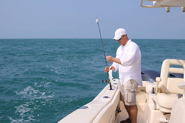 Young man in a boat fishing on the ocean
