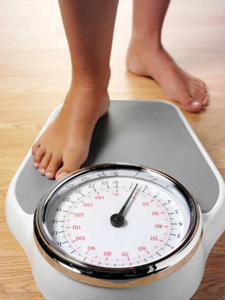 Stepping on Bathroom Scales stock photo