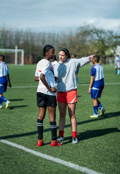 istock Coach giving instruction to female player on field during match 1829011677