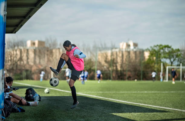 istock Young female soccer player on sideline kicking a ball during a match 1829011680