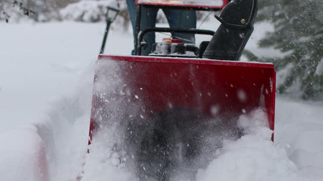 Adult man removing snow with snow blower