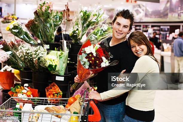 Photo libre de droit de Souriante Jeune Couple Accepter Quil Achète Des Fleurs Dans Un Supermarché banque d'images et plus d'images libres de droit de Activité commerciale