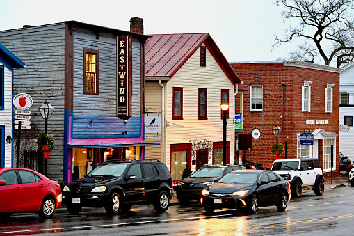 Fairfax, Virginia, USA - December 1, 2023: A car travels through the heart of Old Town Fairfax in the City of Fairfax on a cold, rainy afternoon.