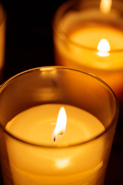 istock Aromatic Candles in Glass: Warm Glow on Dark Background, Close-up 1829018478