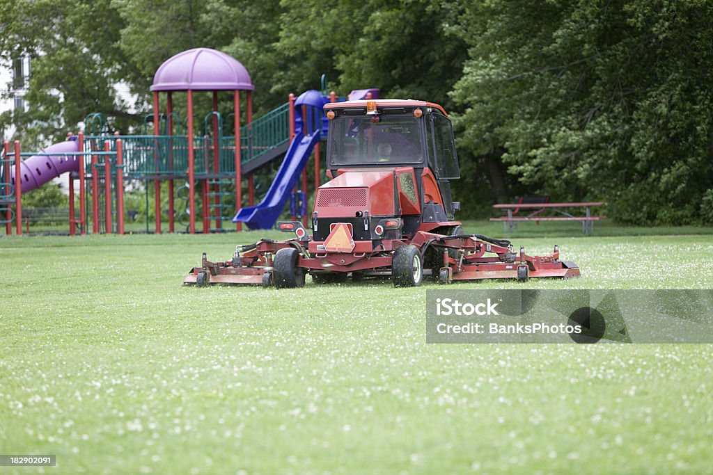 Komercyjne Lawnmower cięcia trawy na boisko do piłki nożnej w pobliżu Plac zabaw - Zbiór zdjęć royalty-free (Kosiarka do trawy)