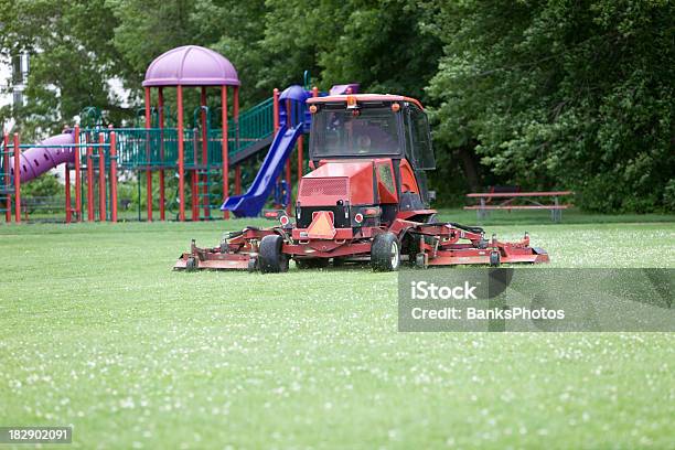 Komercyjne Lawnmower Cięcia Trawy Na Boisko Do Piłki Nożnej W Pobliżu Plac Zabaw - zdjęcia stockowe i więcej obrazów Kosiarka do trawy