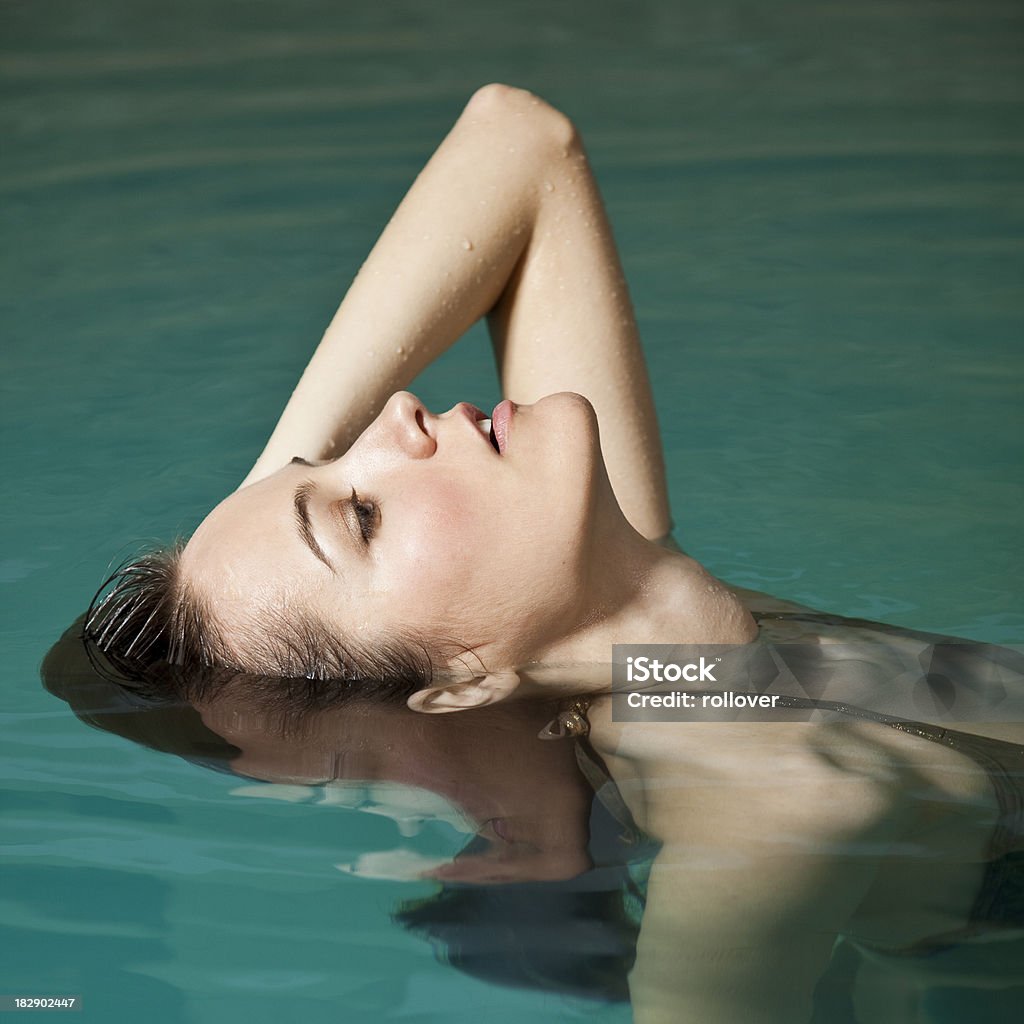 Woman floating Woman floating in swimming pool Summer Stock Photo