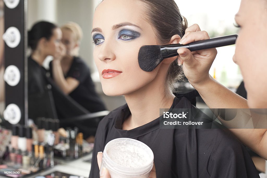 Make-up "Make-up artist, applying lip make-up to model previous a photo shooting, shallow depth of field" Adult Stock Photo