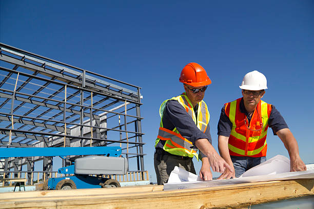 Two Architects Two construction architects review plans at a construction site. foreman stock pictures, royalty-free photos & images