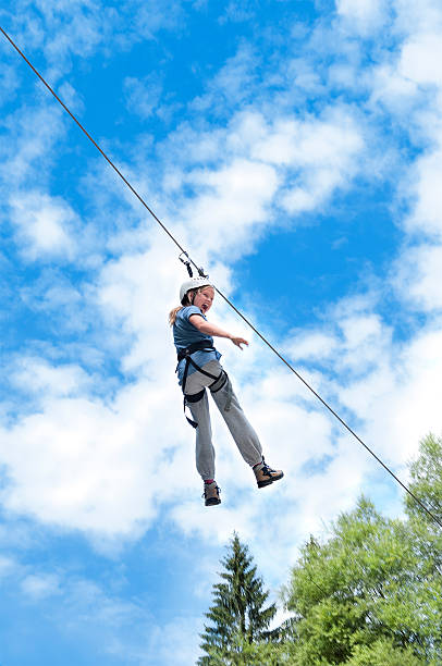 girl flying on a zipline | outdoor adventure stock photo