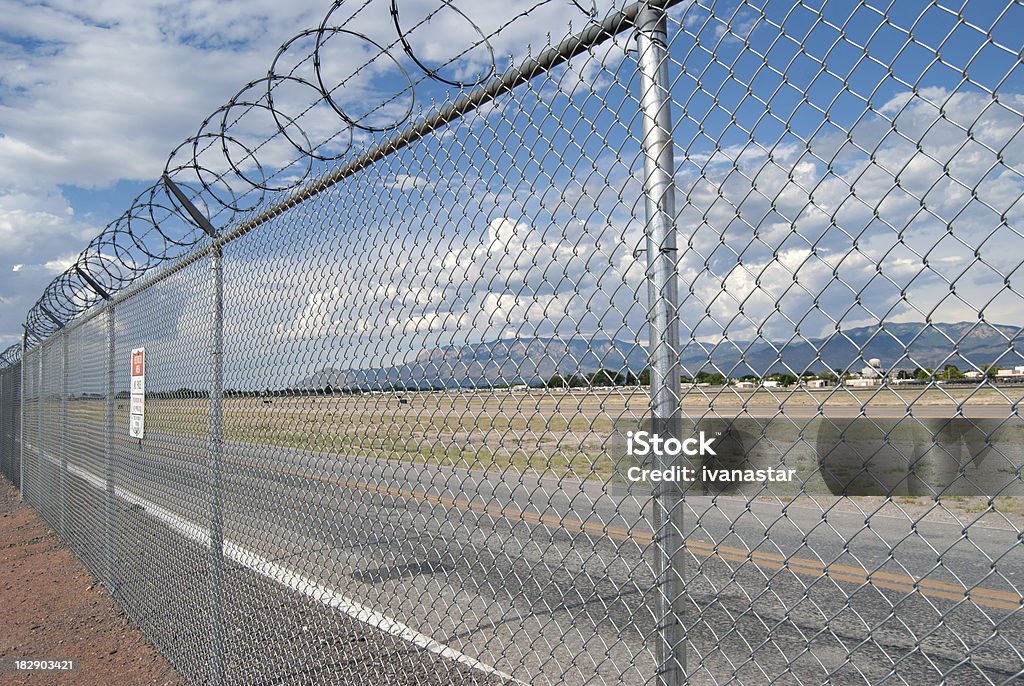 Recinzione di filo spinato sopra aeroporto - Foto stock royalty-free di Rete metallica - Staccionata