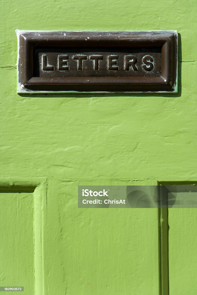 Snail mail Old mail letter box in a distressed green house front door Architectural Feature Stock Photo