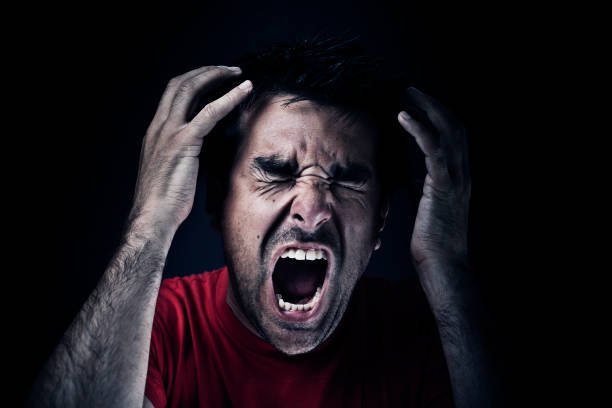 Dark man screaming "Dark man screaming, dark/black background." furious stock pictures, royalty-free photos & images