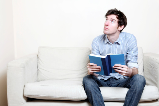 Male in blue shirt reading a book