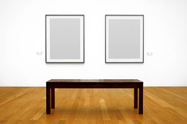 istock Wooden bench in front of picture frames hanging on a wall 182904579
