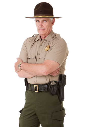 Portrait of a mature male law enforcement officer (highway patrol, sheriff, or park ranger). Isolated on a pure white background.