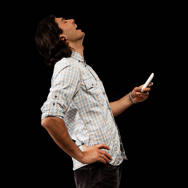 istock Handsome Man in Profile Holding Cell Phone and Laughing 182904922