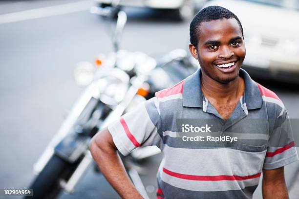 Photo libre de droit de Scène De Rue De Souriant Noir Homme Avec Pilote De Moto En Toile De Fond banque d'images et plus d'images libres de droit de Moto