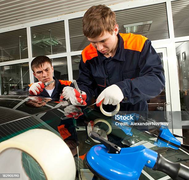 Foto de Dois Mecânicos Real Trabalhando Em Oficina De Automóvel e mais fotos de stock de Consertar