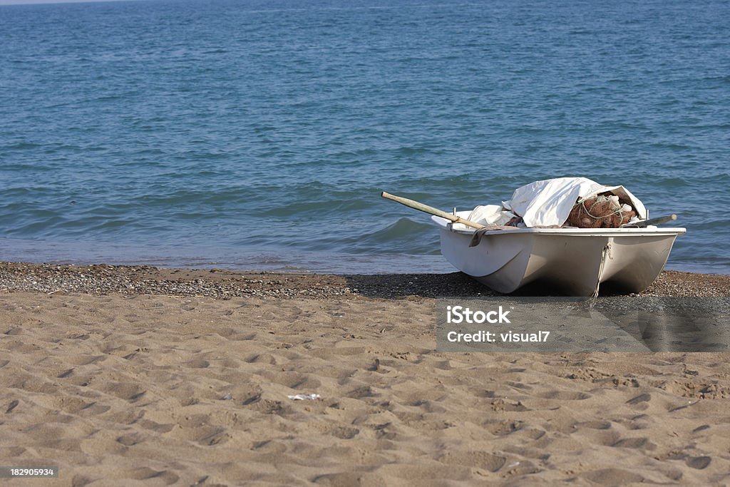 Fishing boat Small fishing boat at a beach with blue sea background Bay of Water Stock Photo