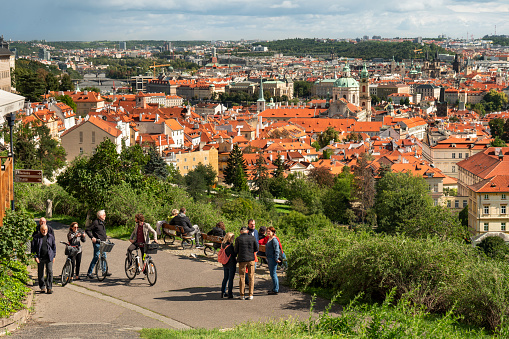 Prague, Czechia - September 18, 2022:  People look out at the Prague city skyline view from the Petrin Gardens orchards overlooking the residential houses in the Mala Strana with the Towers of the Church of Saint Nicholas, Czech Republic Czechia