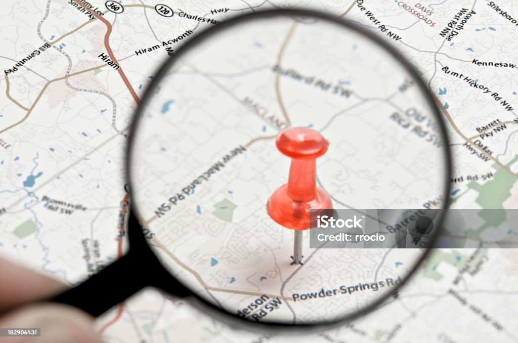 Loupe and pushpin "Hand holding a loupe, spotting a location on the map. Location scouting concept.Click for more of my Thumbtack and Maps images." Cartography Stock Photo