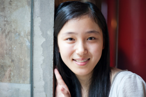 Beautiful asian girl smiling to the camera in a cafe.