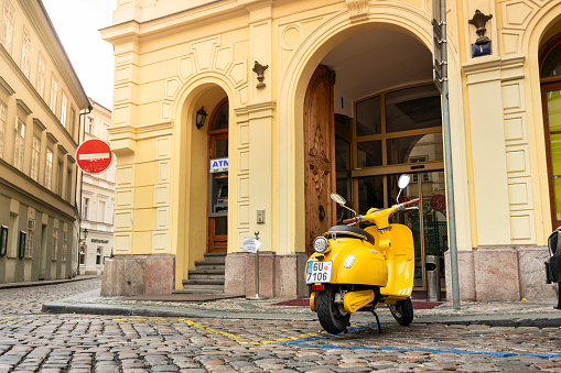 Prague, Czechia - September 18, 2022:  Yellow retro moped motorcycle parked on the historic streets Old Town in Prague Czech Republic Czechia