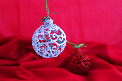 Openwork and shiny Christmas spheres on a red background