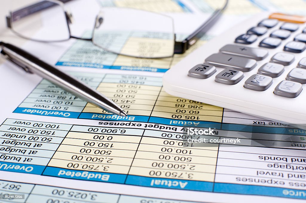 Monthly budget with calculator and pen Monthly budget with numbers calculator glasses and pen Home Finances Stock Photo