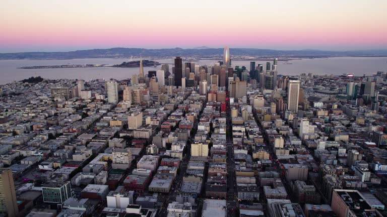 Aerial view of a vibrant sky above the cityscape of San Francisco - pull back, drone shot