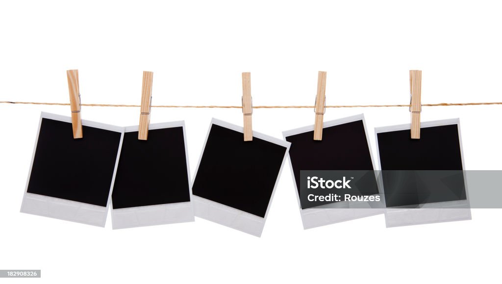 Blank instant photo prints Blank instant photo prints on a washing line. Isolated on white Instant Camera Stock Photo