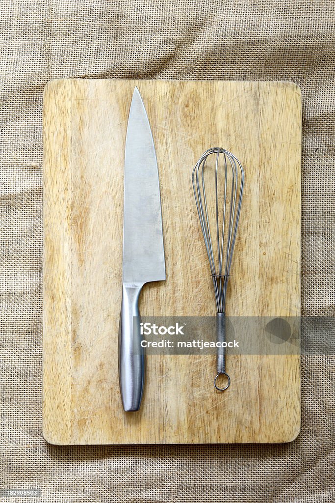 Chopping board and Utensils Wooden chopping board with silver knife and whisk on natural hessian material Burlap Stock Photo
