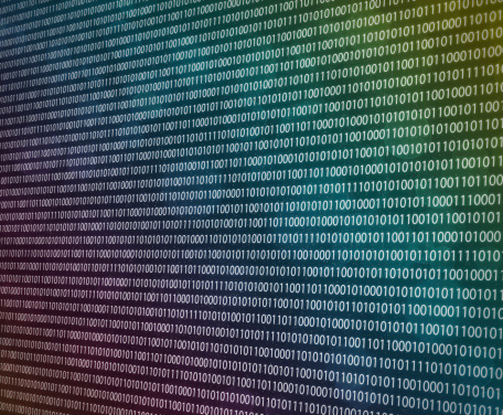 Colourful background image of binary code with bokeh lights.  Modern technology and computing concept