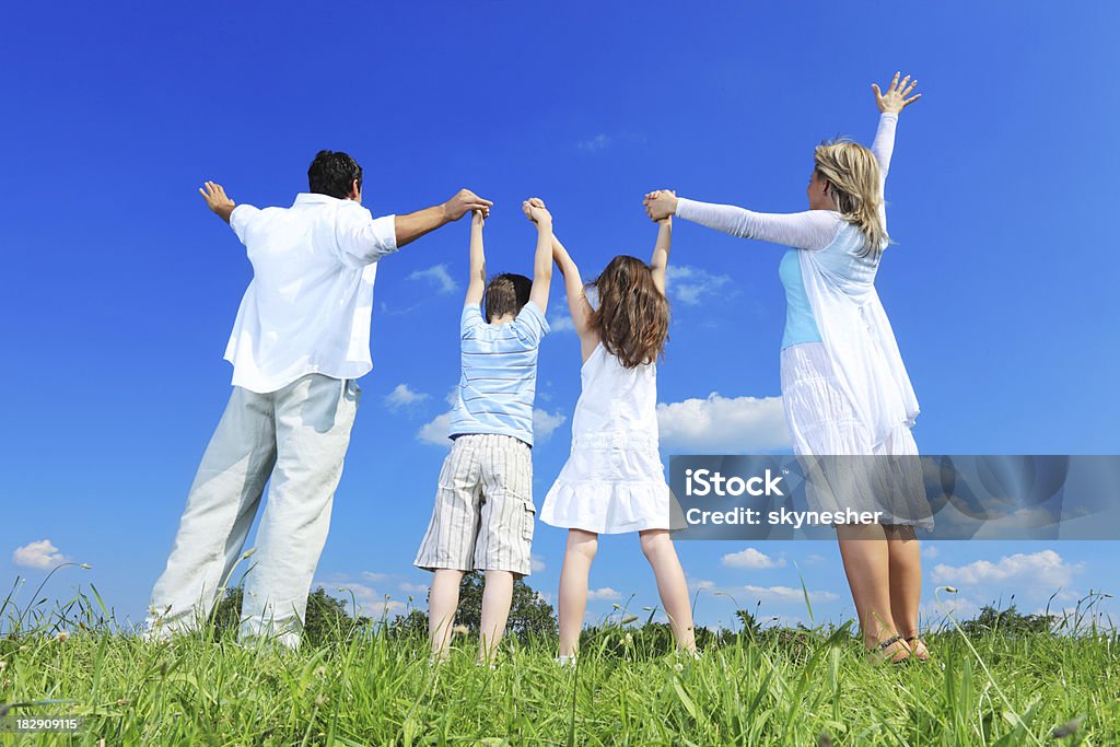 Widok z tyłu Rodzina stojący na zewnątrz z podniesione ręce w górę. - Zbiór zdjęć royalty-free (Rodzina)