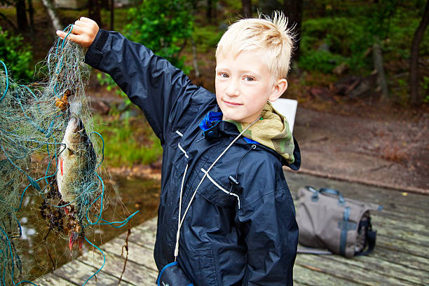 chłopiec trzymać netto z ryb - sweden fishing child little boys zdjęcia i obrazy z banku zdjęć