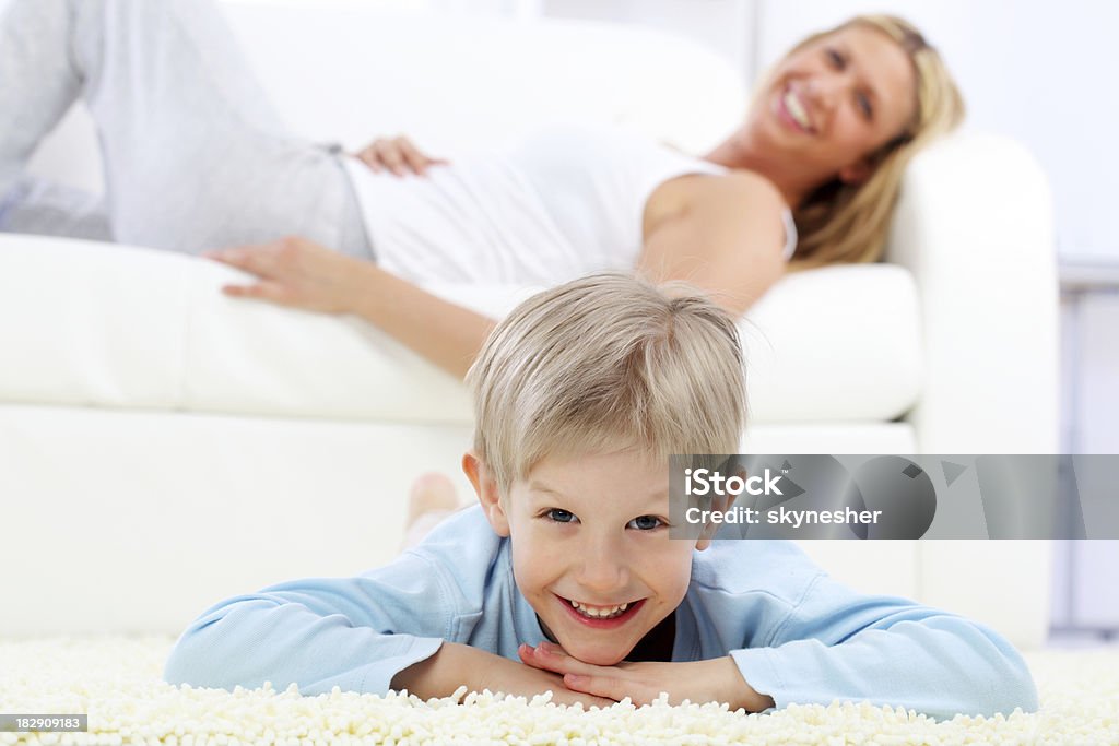 El niño acostado sobre la alfombra. - Foto de stock de Acostado libre de derechos