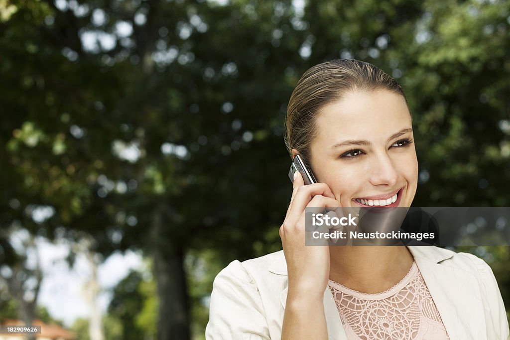Mujer joven en un Cellphone at the Park - Foto de stock de 20 a 29 años libre de derechos