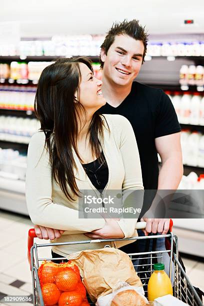 幸せな若いカップルの笑顔のスーパーマーケット乳製品コーナー - 20代のストックフォトや画像を多数ご用意 - 20代, 2人, オレンジ色