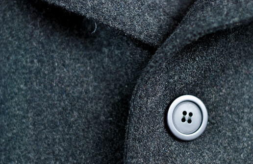 close-up of a classic grey wool coat with button