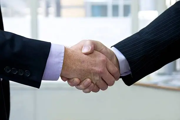 Two business men shaking hands...